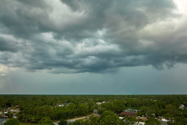 Landschap van donkere onheilspellende wolken die zich vormen op een stormachtige lucht vóór zware onweersbuien boven het landelijke stadsgebied