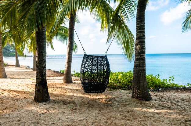 Landschap van een tropisch strand met palmbomen. Schommelstoel op palmbomen.