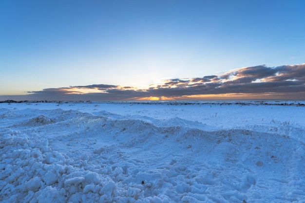 Landschap van het strand Volledig besneeuwd zwart zandstrand met gouden zonsopgang