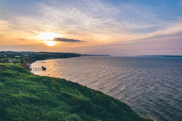 Landschap van heuvelachtige kust naast het estuarium van rivieren bij zonsonderganglicht