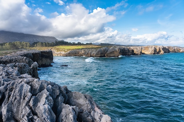 Landschap van kliffen in de Cantabrische Zee met uitzicht op hoge bergen op de achtergrond Asturias Spanje