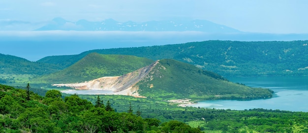 Landschap van Kunashir Island-meren en lavakoepels in het centrum van Golovnin-vulkaancaldera het eiland Hokkaido is zichtbaar in de verte in de zee