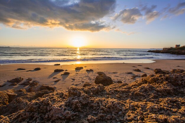 Landschap van rotsachtig strand bij zonsondergang