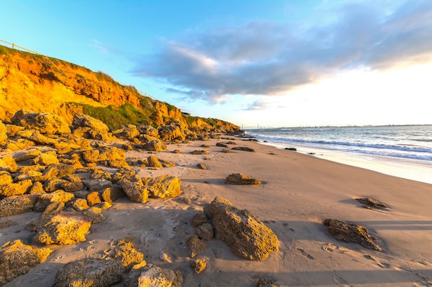 Landschap van rotsachtig strand bij zonsondergang