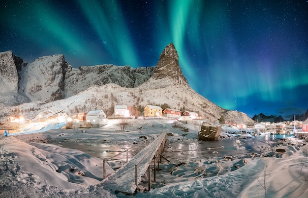 Landschap van sneeuwberg met dageraadborealis in Skandinavisch dorp