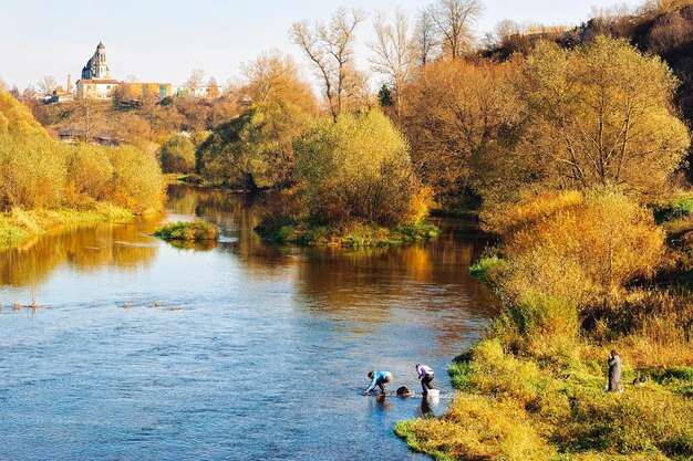 Landschap van vrouwen die kleren wassen op de Protva-rivier in de stad Borovsk in de herfst in Rusland.