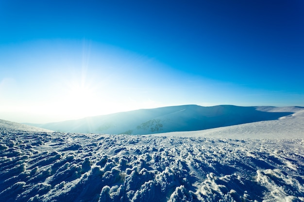 Landschap van witte bergdal bedekt met sneeuw op duidelijke ijzige winterdag