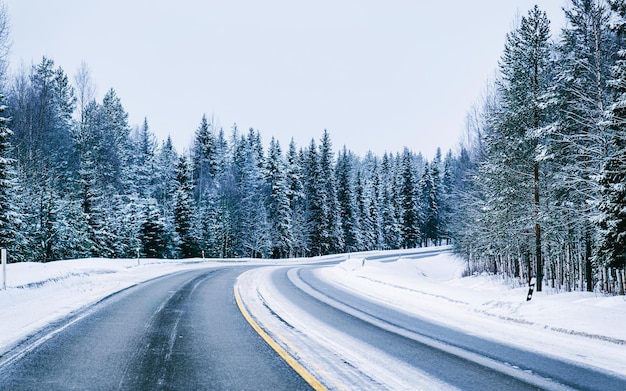 Landschap zonder auto's in lege sneeuwweg in Finland. Vakantiereis op snelweg met de natuur. Landschap met winterrit op vakantiereis voor recreatie. Bewegingsrit in Europa. Vervoer op oprit