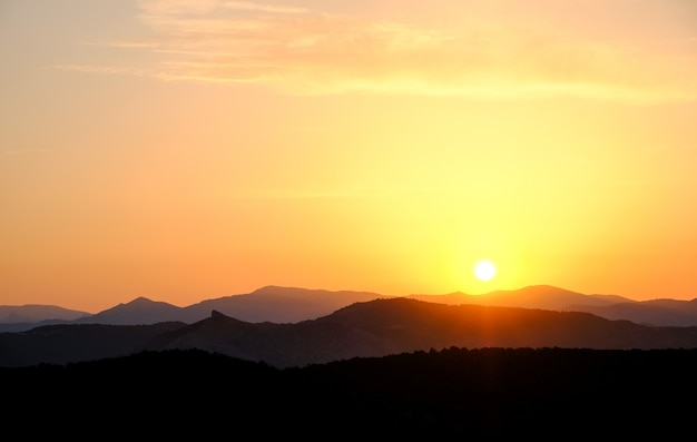 Landschap, zonsondergang in de lucht tegen de bergen, bergketens tijdens zonsondergang