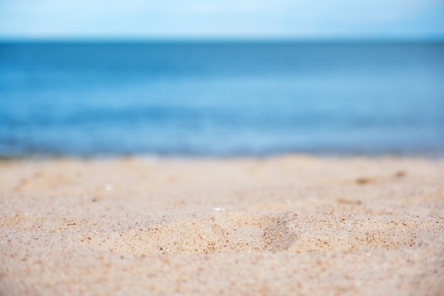 Landschapsbeeld van zand op tropisch strand met blauwe zee en hemelachtergrond