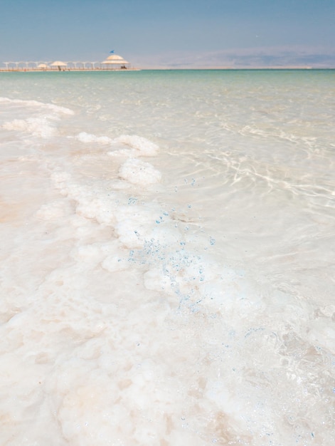 Landschapsmening op de zoutkristallenformaties van de dode zee, helder cyaangroen water op het strand van ein bokek, israël