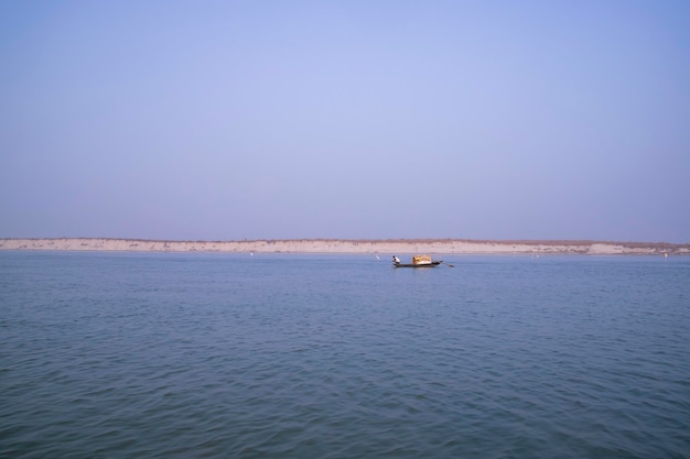 Landschapsmening van de Padma-rivier op een vissersboot met een zandeiland onder de blauwe hemel