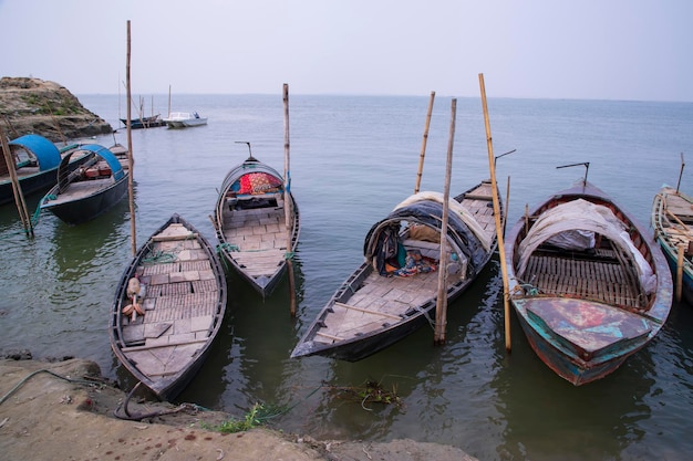 Landschapsmening van enkele houten vissersboten aan de oever van de Padma-rivier in Bangladesh