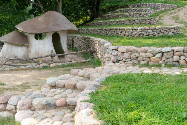 Landschapsontwerp Trapvormig terras beveiligd met ruwe stenen Hobbitdorp Designhuis in de vorm van een grote paddestoel