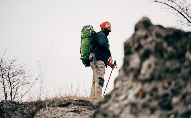Landschapsopname van reiziger, bebaarde man die wandelt en bergbeklimt tijdens zijn reis Toeristische jonge man die in de bergen wandelt, is klaar met zijn track Reizen mensen sport en gezonde levensstijl concept