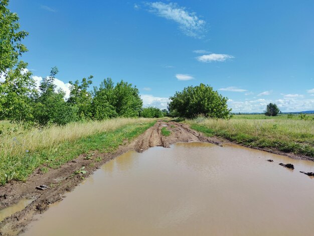 Foto landweg na de regen op de achtergrond van een prachtige blauwe hemel