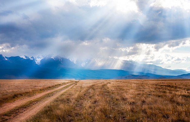 landweggetje in de zon tegen de achtergrond van een berglandschap