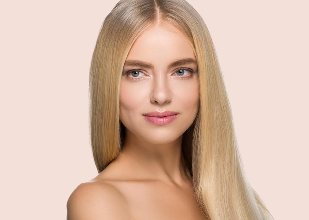 Lang glad haar schoonheid vrouw portret blond kapsel. Haar gezicht aanraken. Kleur achtergrond. Roze