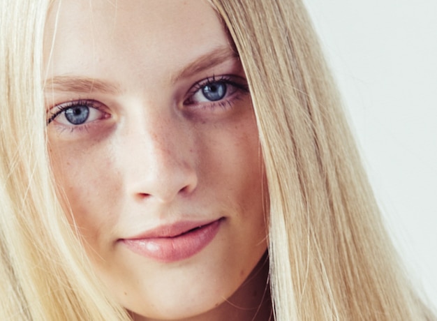 Lang haar blond jong model. Schoonheidsmeisje met krullend perfect kapsel. Studio opname.