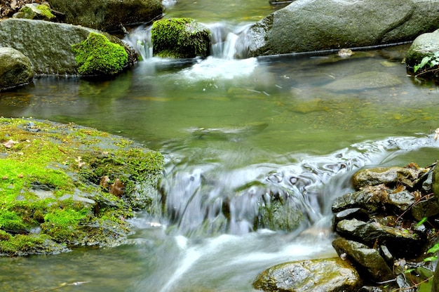 Lange blootstellingsweergave van een verborgen rivier in de Krim, Oekraïne Een steen tegen een wazig waterpatroon is ideaal voor gebruik op de achtergrond