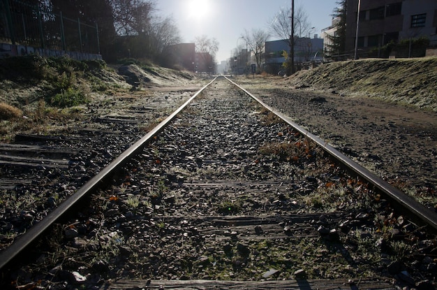 Lange spoorlijn met de zon aan het eind, een manier van vervoer per trein.