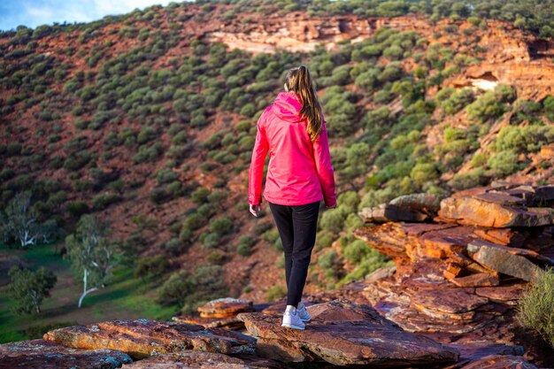 langharig meisje loopt langs een bergkam op de rode rotsen van het nationale park Kalbarri in West-Australië