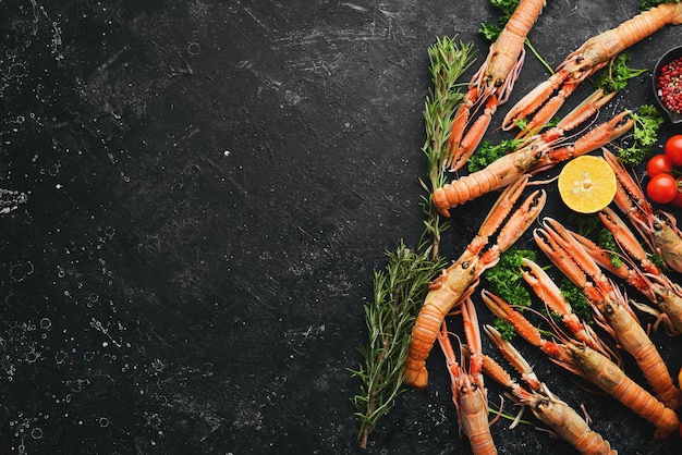 Langoustines Norway lobster on a black stone background Raw scampi Top view Free copy space