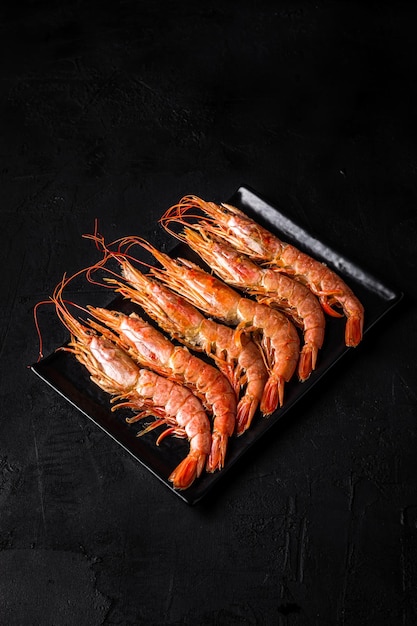 Langoustines op een bord geschoten op zwarte achtergrond