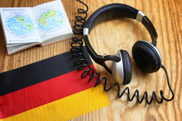 Language course headphone and flag on wooden table