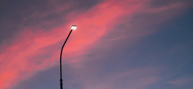 Lantaarnpaal bij zonsondergang Tijd bij zonsondergang Copy space Een artikel over elektriciteit