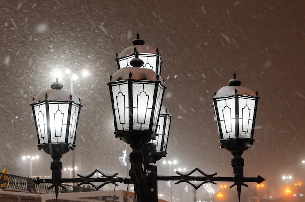 Lantaarnpaal 's nachts in de winter in een sneeuwstorm.