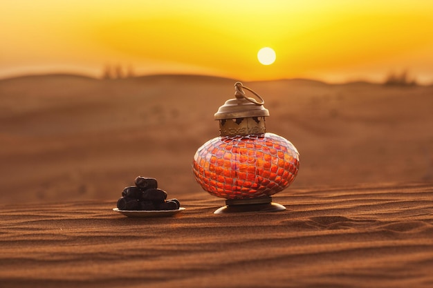 Photo lantern and dates in the desert at a beautiful sunset symbolizing ramadan kareem