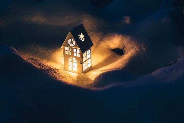 夕方に雪の上でろうそくを燃やすランタンハウス。