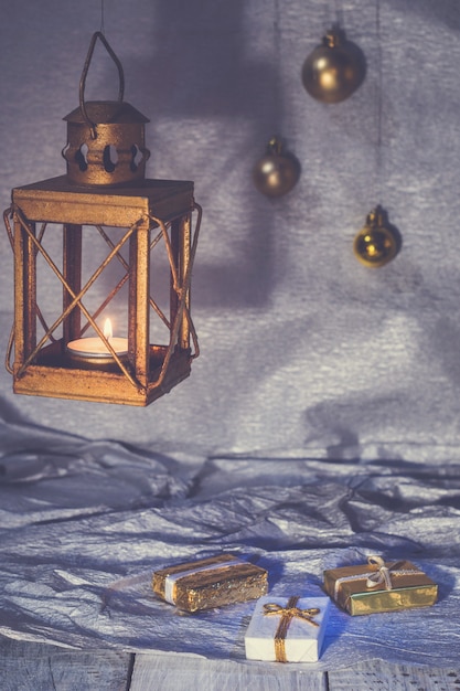 Фото Фонарь со свечой и елочными украшениями на серебряном фоне
