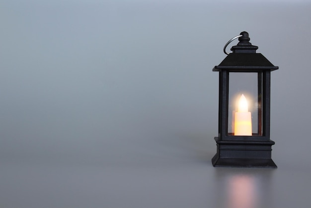 Lantern with burning candle glowing Grey background Copy space Muslim holy month Ramadan Kareem