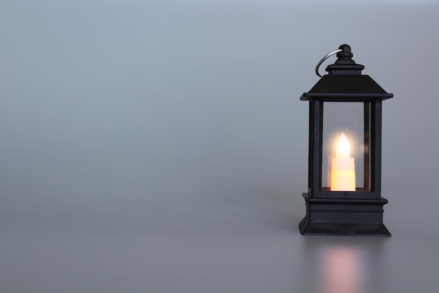 Lantern with burning candle glowing grey background copy space muslim holy month ramadan kareem