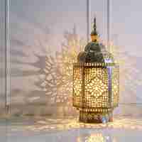 Photo a lantern with a gold design on it is on a table