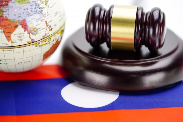 Фото Флаг лаоса и молоток судьи с картой мира глобуса. закон и справедливость судебной концепции.