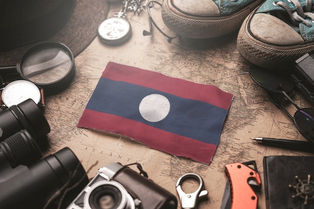 Laos Flag Between Traveler's Accessories on Old Vintage Map. Tourist Destination Concept.