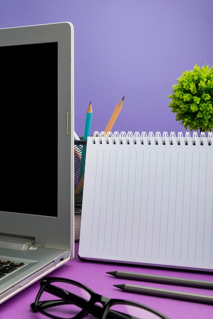 花とマグカップを備えた机の上のコンピュータ画面に提示された植物と一杯のコーヒーの重要な発表をテーブルに置いたラップトップ