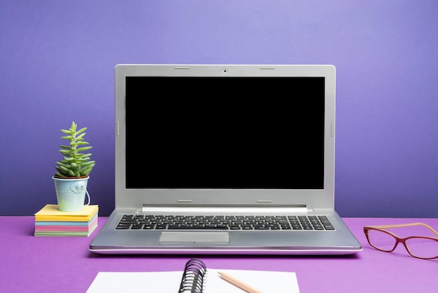 Ноутбук с важной информацией на столе с растением и чашкой кофе Важные объявления представлены на экране компьютера на столе с цветком и кружкой