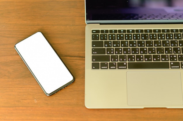 Ноутбук и смартфон с пустой экран на столе