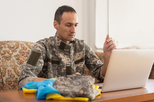 Laptop, Bericht voor wereldvrede. militair met laptop en vlag van oekraïne. online conferentie militair