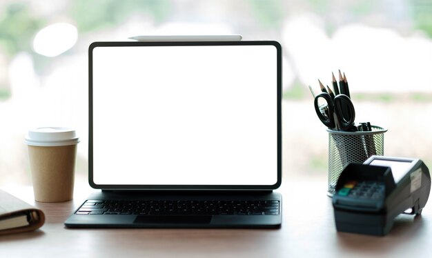 Laptop blank screen with EDC machine on a table in a coffee shop