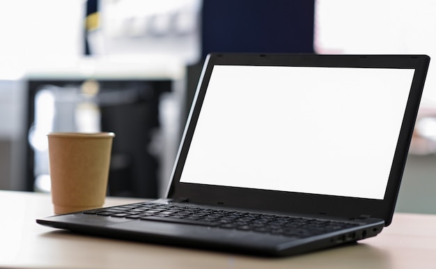 Photo laptop blank screen with take away coffee on the table in office.