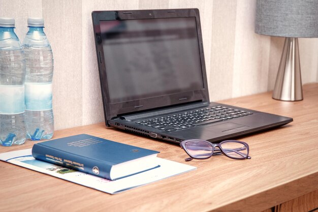 laptop book glasses and water on the table