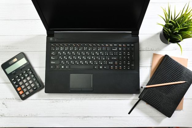 Laptop and calculator on a wooden table