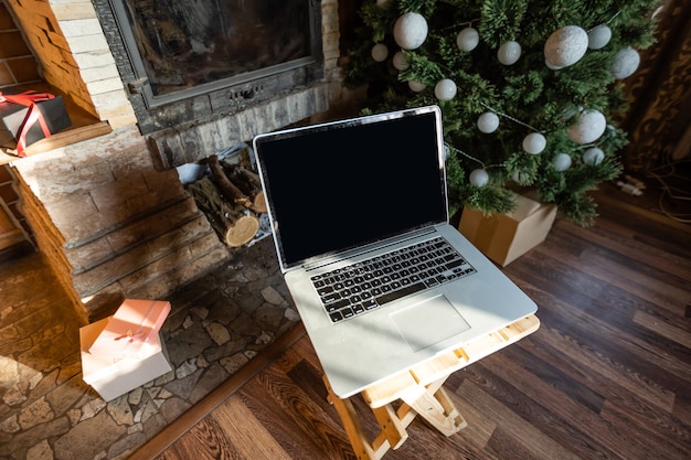 laptop and christmas tree in an old wooden house