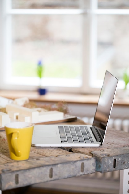 Laptop and coffee cup in modern informal office