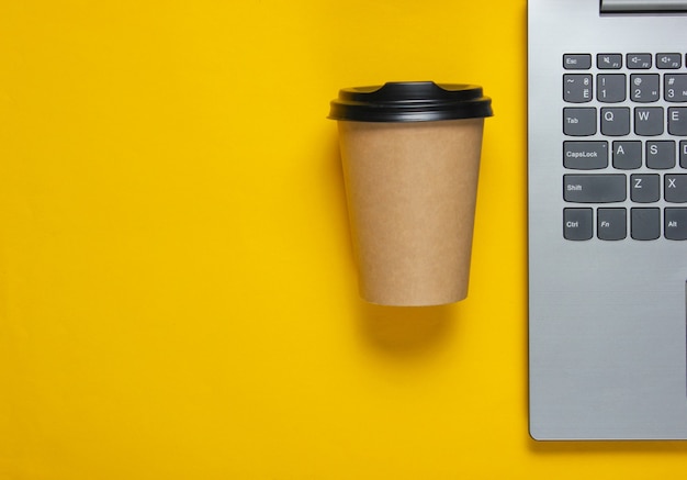 Laptop and coffee cup on yellow paper